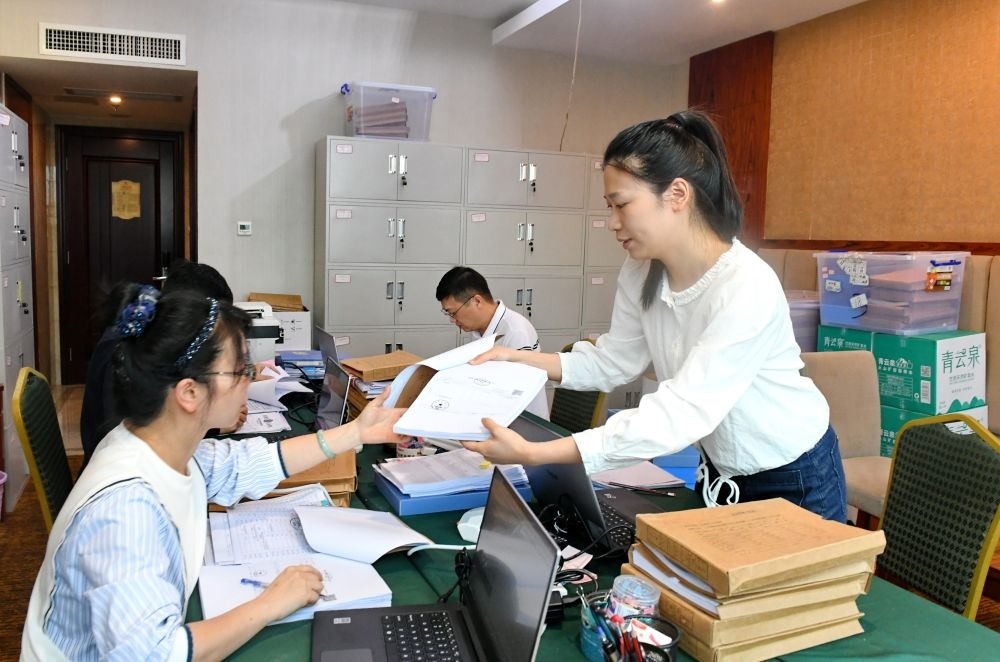 福州市委巡察機(jī)構(gòu)對全市法院系統(tǒng)開展提級聯(lián)動交叉巡察。在永泰縣駐地，巡察組工作人員查看財(cái)務(wù)憑證（2024年5月21日攝）。新華社記者 林善傳 攝