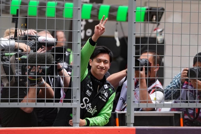 2024年4月19日，索伯車隊中國車手周冠宇（中）在練習(xí)賽前向觀眾致意。當(dāng)日，F(xiàn)1中國大獎賽在上海開賽。中國車手周冠宇主場首秀參賽。新華社記者 夏一方攝