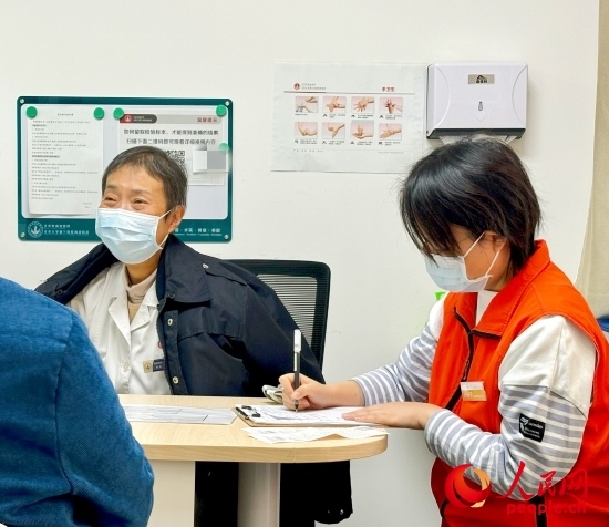 秦苑（中）接診患者。人民網(wǎng)記者 金慧慧攝