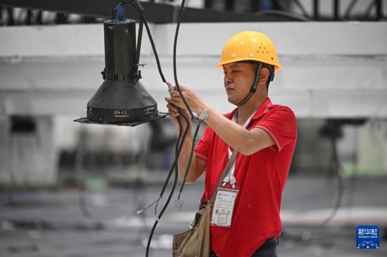 4月4日，工作人員在海南國(guó)際會(huì)展中心內(nèi)布設(shè)燈光。