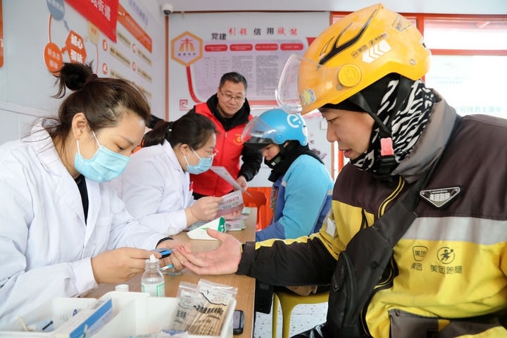 2025年3月5日，志愿者在山東省棗莊市市中區(qū)一工會驛站為外賣員免費(fèi)測量血糖。新華社發(fā)（王海楠攝）