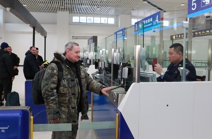 2024年12月10日，在黑河公路口岸旅檢大廳，黑河出入境邊防檢查站民警為首班次客車入境旅客辦理邊檢通關(guān)手續(xù)。當日，中國黑河公路口岸—俄羅斯卡尼庫爾干公路口岸旅客運輸正式開通。新華社發(fā)（劉松攝）