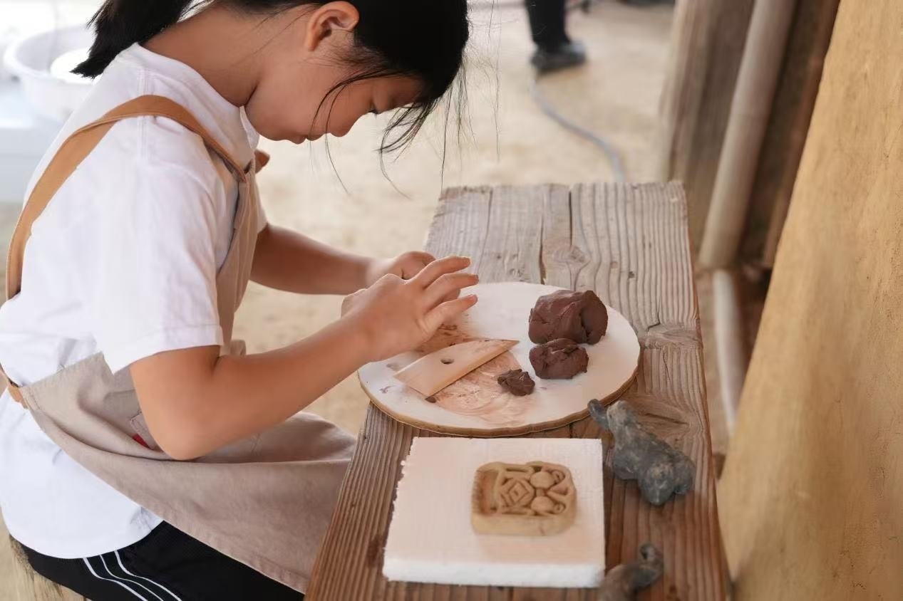 游客制作良渚特色陶藝品。良渚博物院供圖