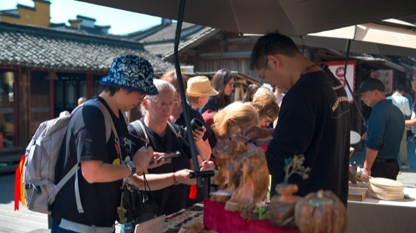 “五一”期間，游客正在烏鎮(zhèn)“水鄉(xiāng)碼頭”挑選購買文創(chuàng)產(chǎn)品。受訪者供圖