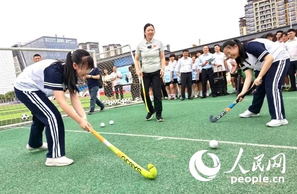 陳朝霞（中）指導(dǎo)學(xué)生體驗(yàn)曲棍球。 人民網(wǎng)記者 楊磊攝