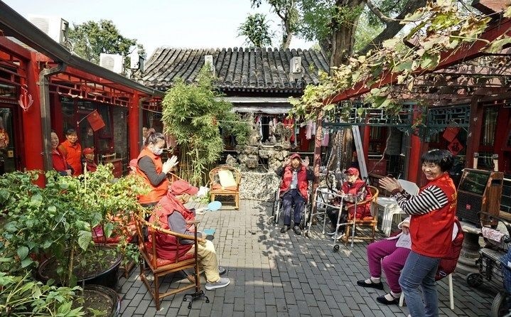 2024年10月12日，鐘樓灣胡同的老年人在社區(qū)內(nèi)的四合院養(yǎng)老驛站休閑。2017年起，北京市先后開展了兩輪背街小巷環(huán)境整治提升行動(dòng)，完整保留了中軸線生活建筑群的歷史信息，并根據(jù)居民的生活和居住方式進(jìn)行適配化的更新和改造，極大地改善了生活環(huán)境。2023年鐘樓灣胡同被評(píng)為“北京最美街巷”。