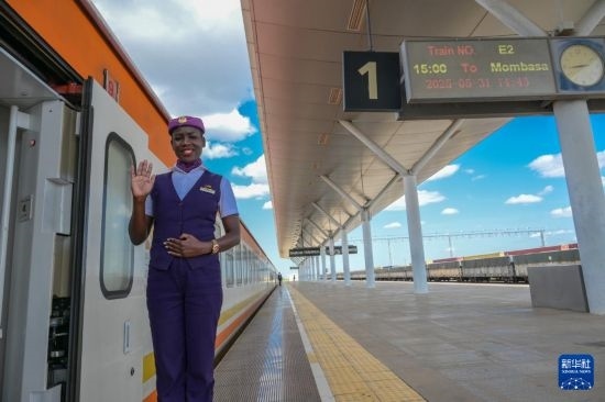 5月31日，在蒙內(nèi)鐵路內(nèi)羅畢站，一名乘務員在即將開往蒙巴薩的E2次列車旁等候乘客。新華社記者 楊光 攝