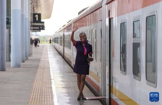 5月31日，在蒙內(nèi)鐵路內(nèi)羅畢站，一名乘務員在即將開往蒙巴薩的E2次列車旁等候乘客。新華社記者 李亞輝 攝