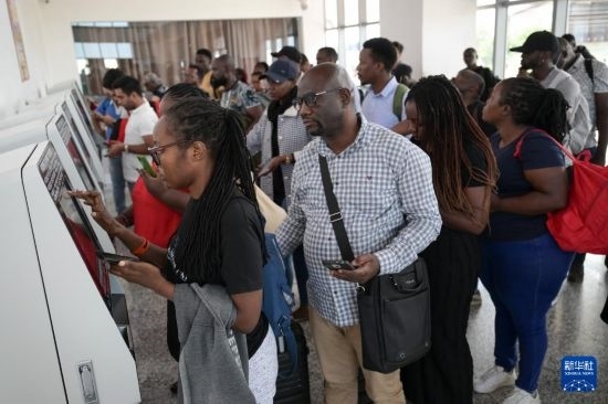 5月31日，在蒙內(nèi)鐵路內(nèi)羅畢站，乘客在自助取票機前排隊取票。新華社記者 楊光 攝