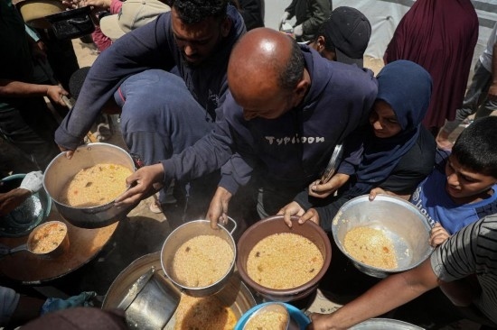 5月28日，人們?cè)诩由吵俏鞑康纳程犭y民營領(lǐng)取救助食物。新華社發(fā)（里澤克·阿卜杜勒賈瓦德攝）