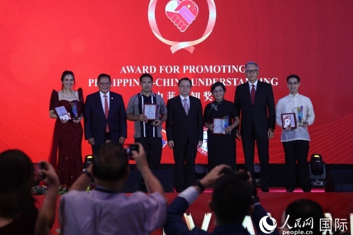 黃溪連大使和菲中了解協(xié)會主席與榮獲“友誼獎”的獲獎者合影留念。人民網(wǎng)記者 樊帆攝